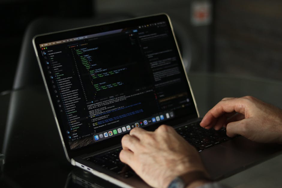 A photograph of a computer screen displaying lines of HTML code in a dark-themed editor. The code features colorful syntax highlighting with tags such as <h1> and <div>, attributes like 'class' and 'a